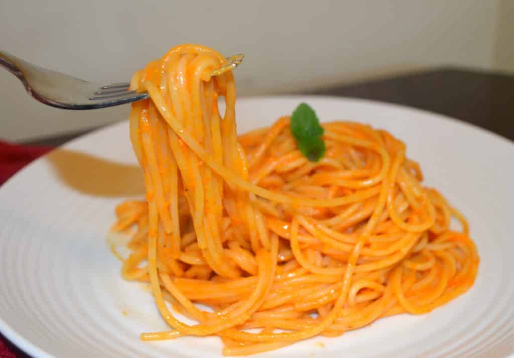 a plate of spaghetti with roasted pepper sauce 