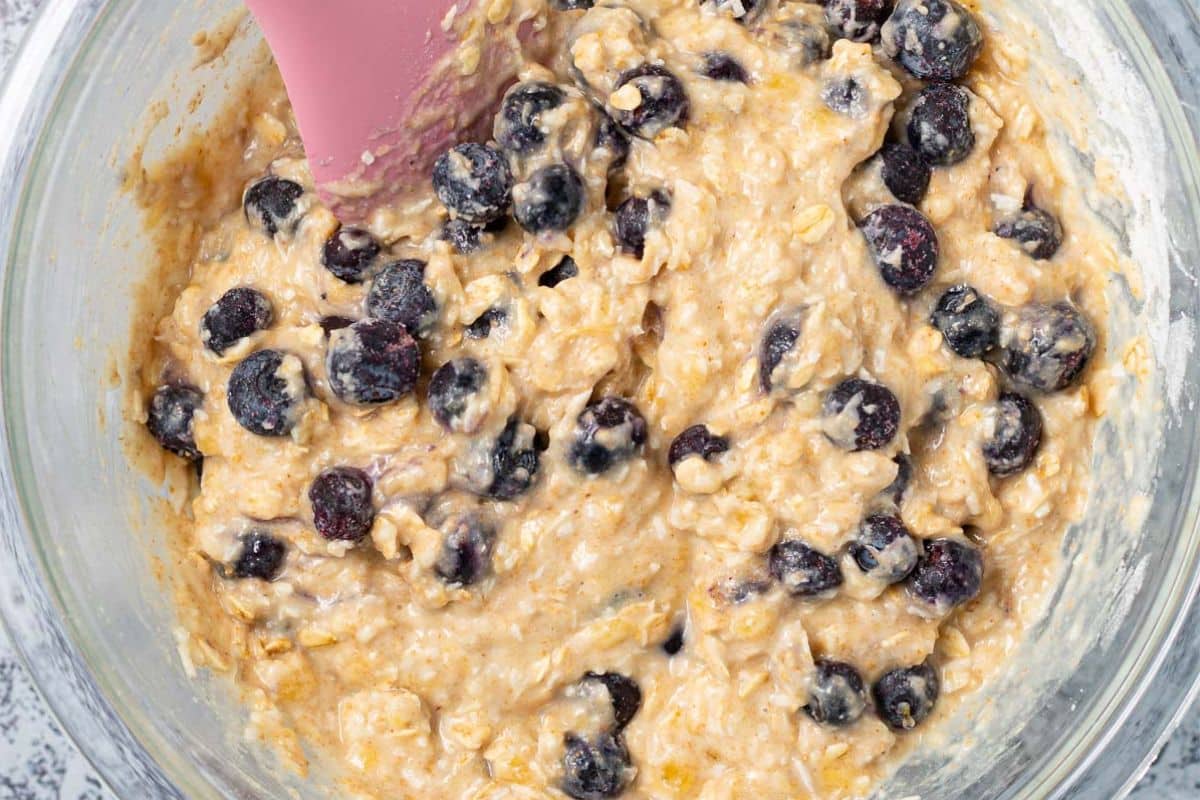 muffin batter with blueberries stirred through it.