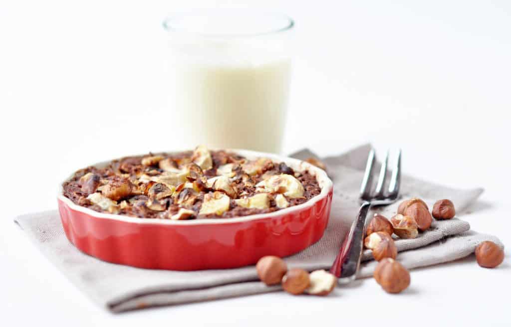 A mouthwatering baked oatmeal with a deliciously crusty exterior and a soft, creamy, chocolatey oaty interior, crunchy roasted hazelnuts and soft, sweet baked banana.