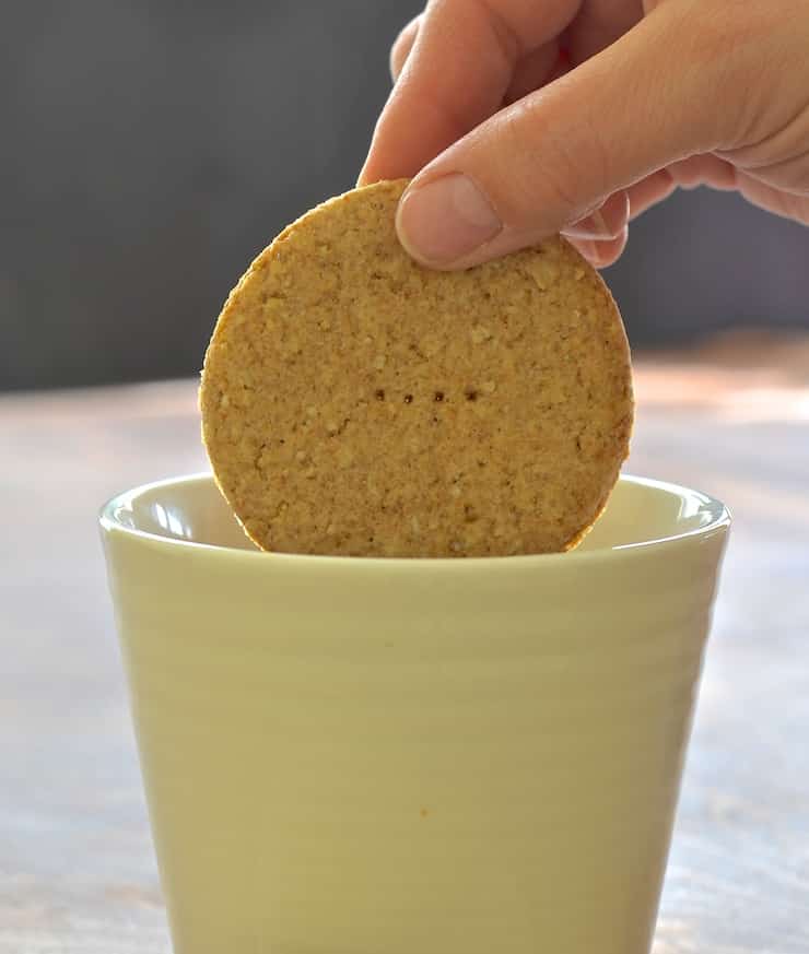 a biscuit being dipped in a cup of tea