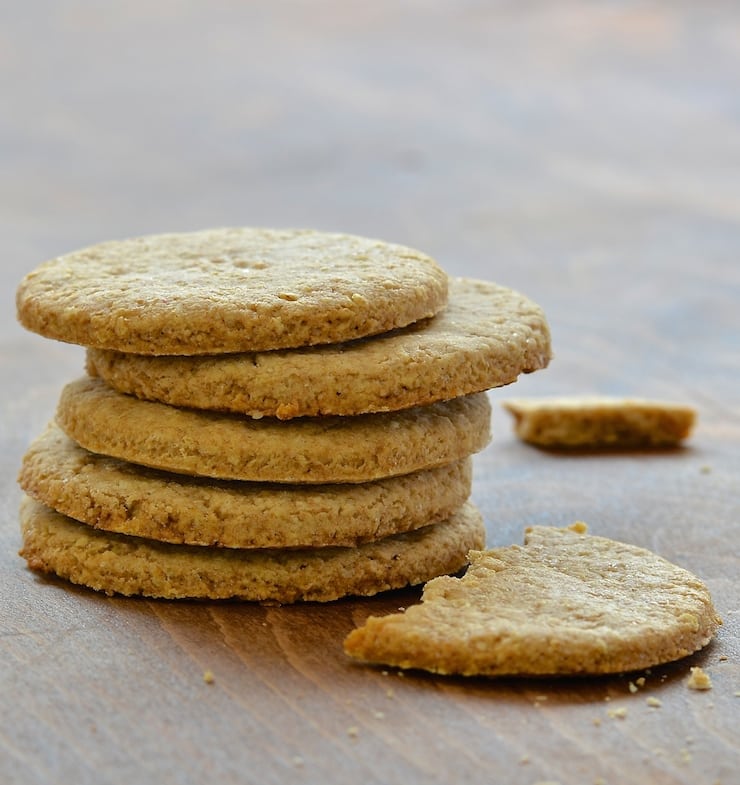 a stack of vegan digestive biscuits with one half to the side 