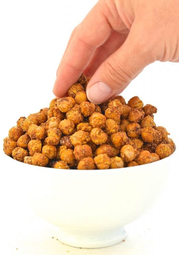 cheese & onion crispy roasted chickpeas in a bowl with a hand taking some 
