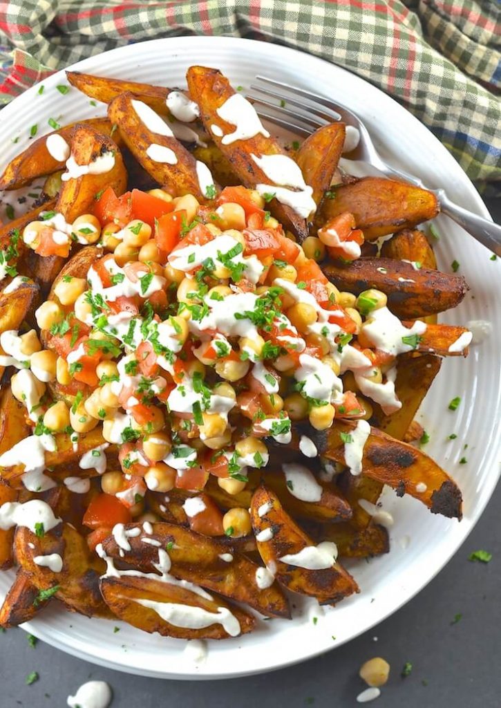 Loaded Taco Fries on a plate and drizzled in lime crema. Shot taken form above