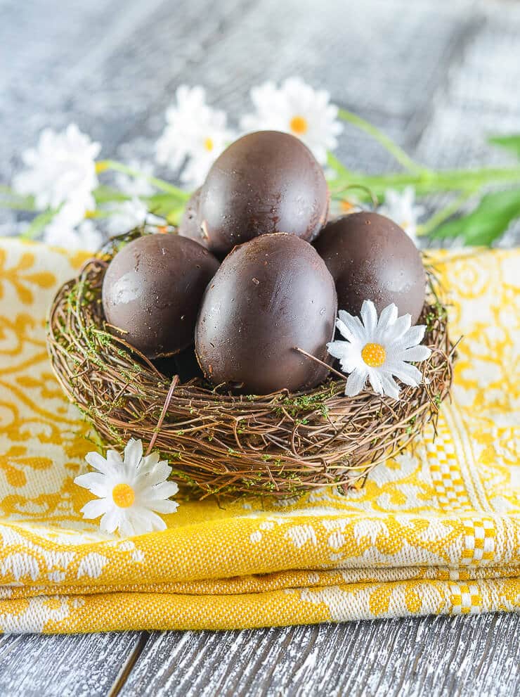 Homemade Vegan Creme Eggs nestled in a pretty little bird's nest with daisy's scattered around 