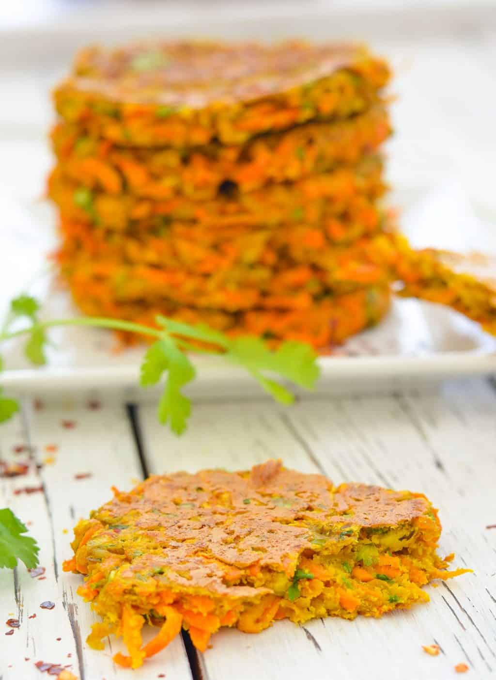 Interior shot of Curried Carrot Fritters with stack of fritters in the background