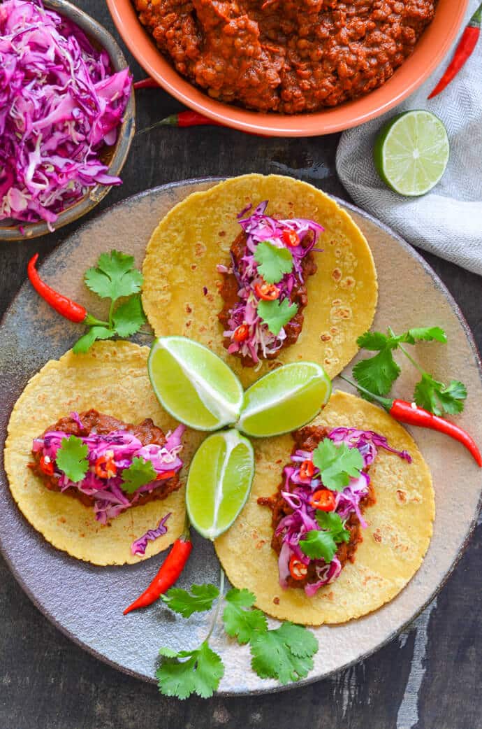 enchilada lentil tacos with lime slaw from above with sliced lime and chili garnish 