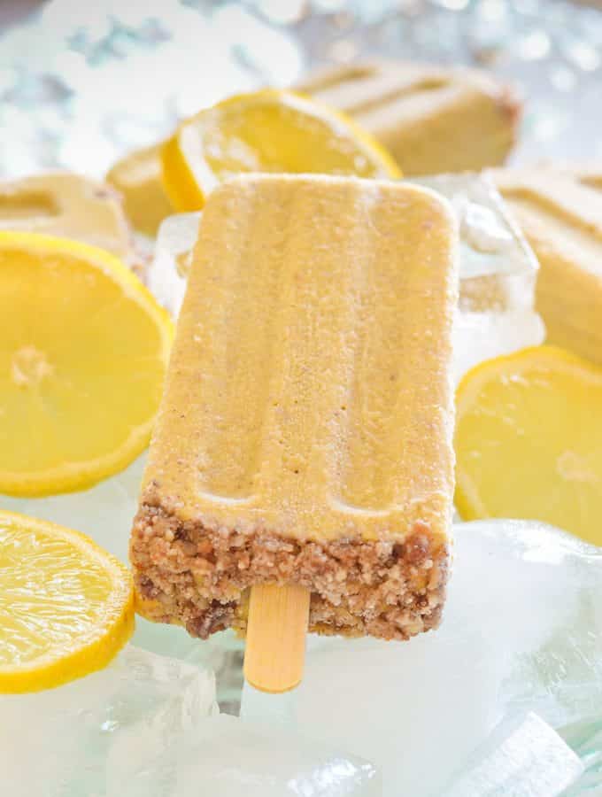 Creamy Lemon Cheesecake Pop surrounded by ice and slices lemons