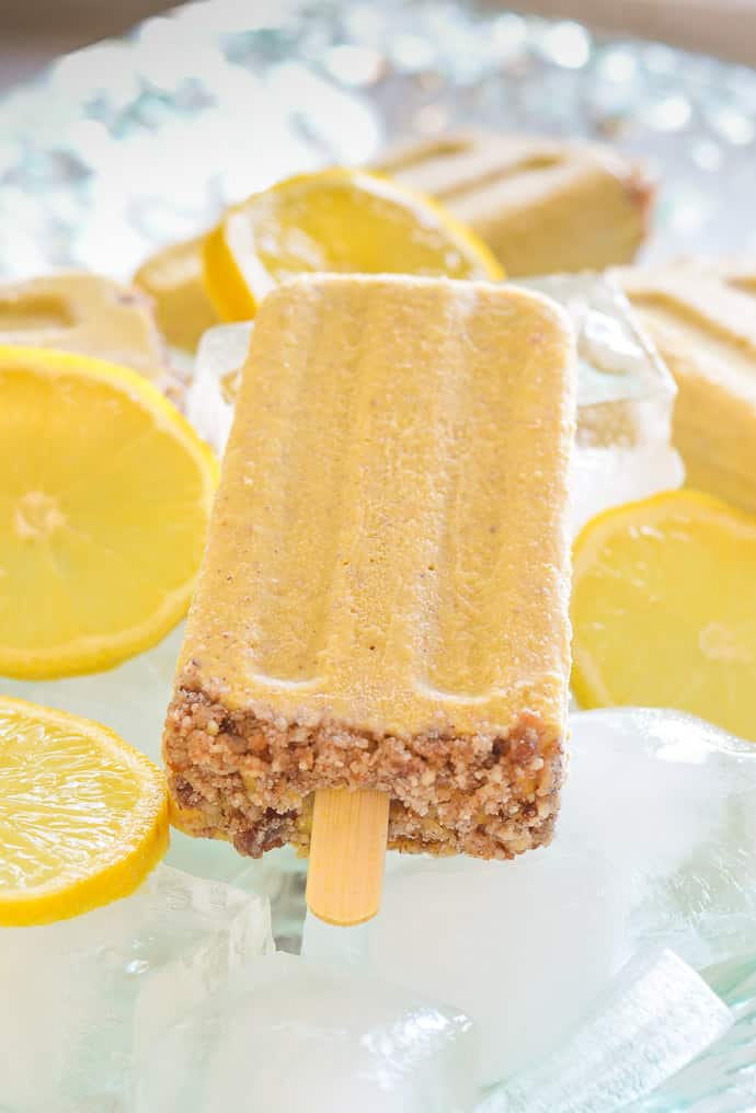 Creamy Lemon Cheesecake Pop surrounded by ice and slices lemons