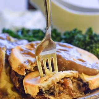 Close up shot of a slice of Easy Vegan Mushroom Pie with gravy.