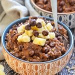 Healthy Chocolate Instant Pot Steel Cut Oats in a bowl, topped with a pile of chopped banana and chocolate chips.