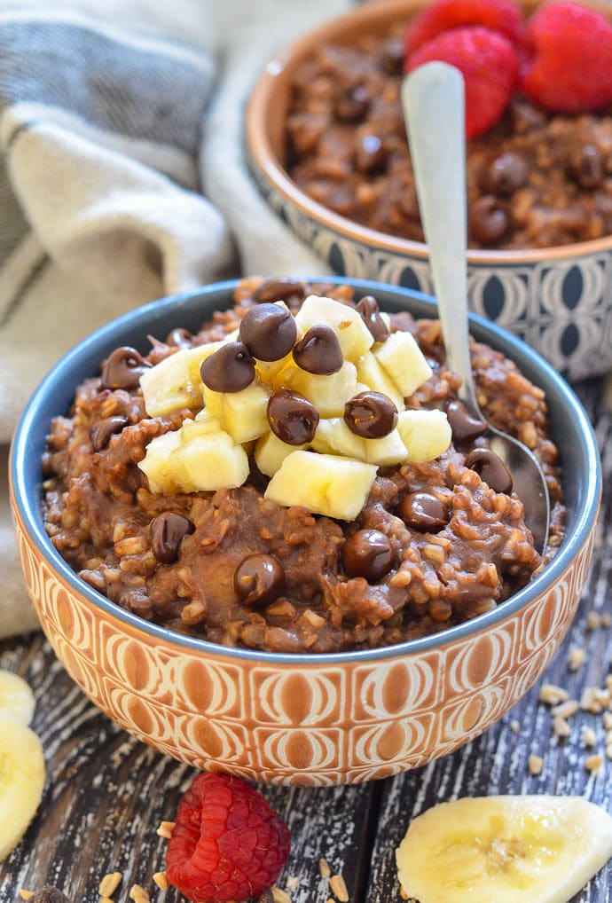 Healthy Chocolate Instant Pot Steel Cut Oats in a bowl, topped with a pile of chopped banana and chocolate chips.