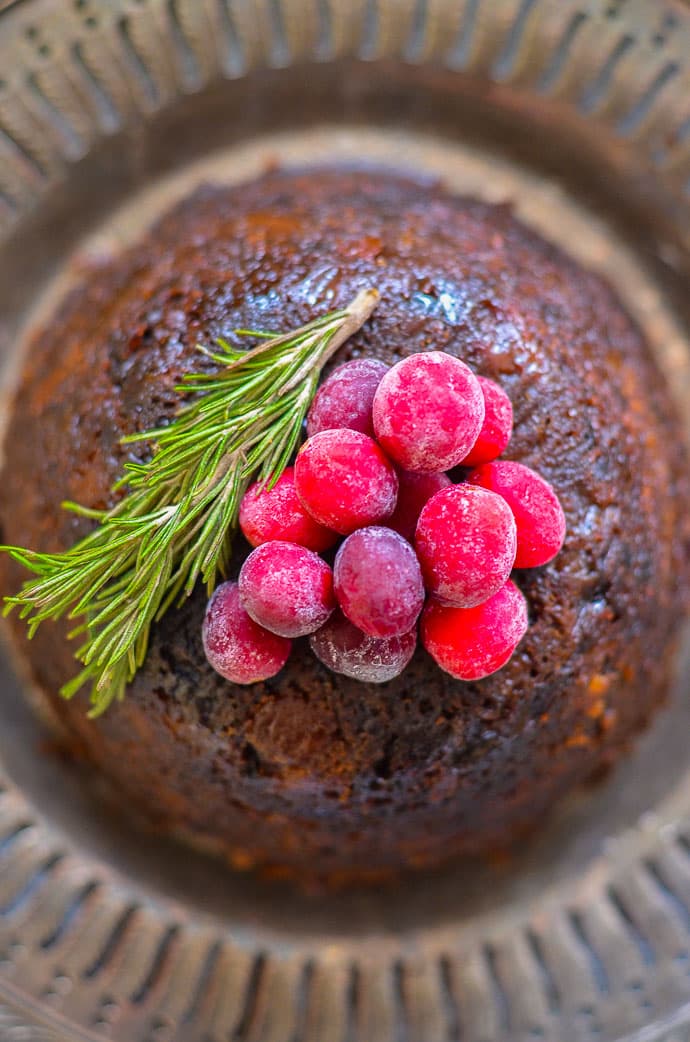 Close up shot of frosty cranberries on top of a Vegan Christmas Pudding