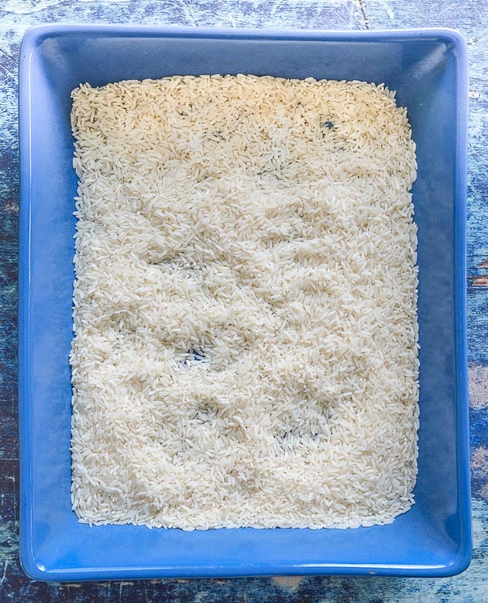 dried rice in a blue dish - the 1st step in making Easy Oven Baked Garlic Mushroom Rice