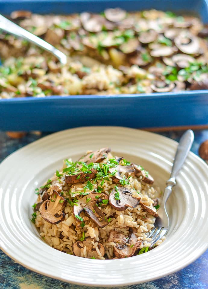 Easy Oven Baked Garlic Mushroom rice in a bowl and sprinkled with parsley