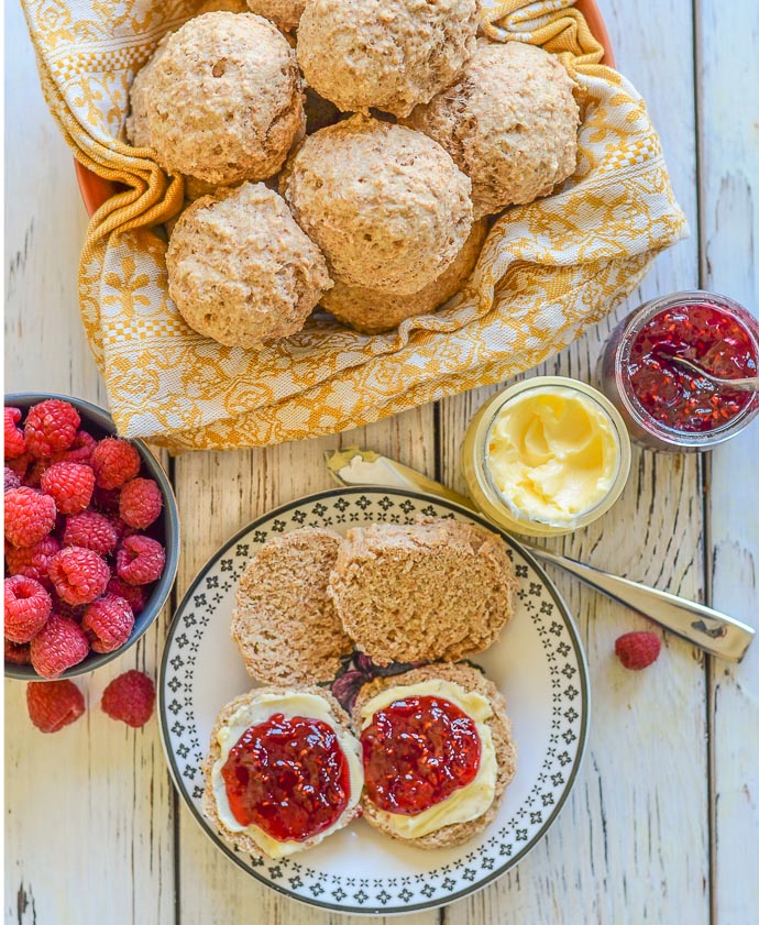 A bowl of Healthy Vegan Biscuits & a couple on a plate, split with butter & jam