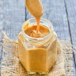 Date Caramel drizzling from a spoon into a jar