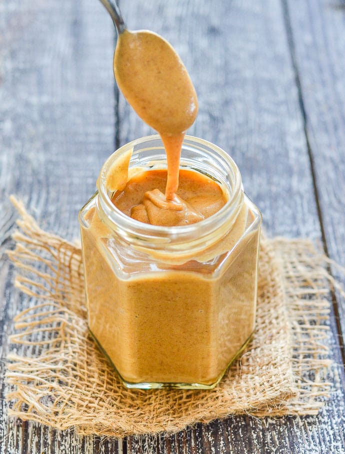 Date Caramel drizzling from a spoon into a jar