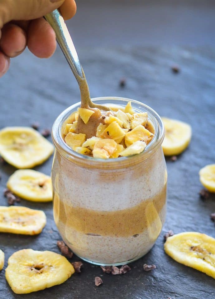 chia seed pudding with caramel in a jar with a spoon being put into it