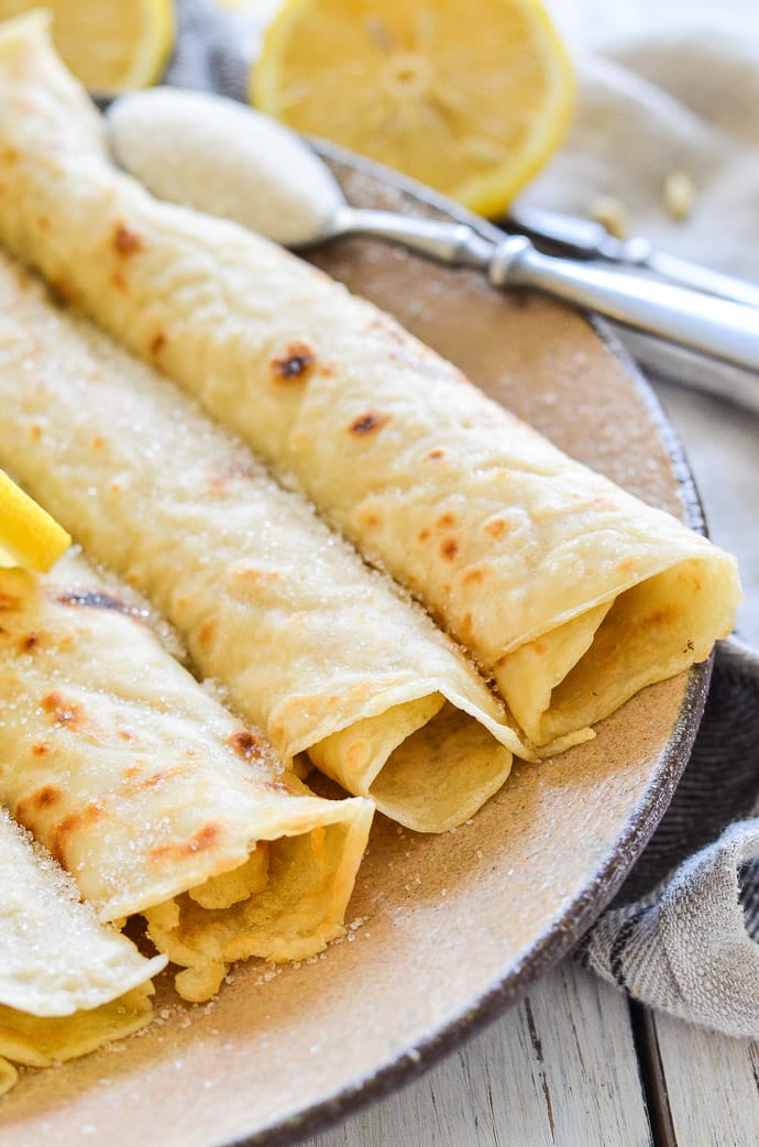 Close up shot of rolled Vegan English Pancakes sprinkled with sugar and lemon