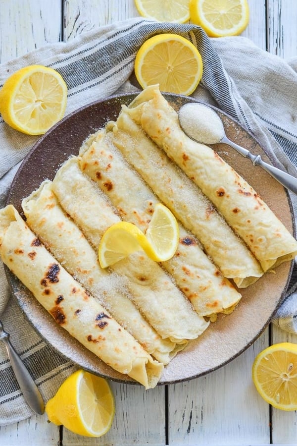 Foolproof Vegan English Pancakes. Quick & easy to make & great for dessert or brunch! They are beautifully freckled and so good straight from the pan, served glistening with fresh lemon juice & sugar. #pancakes #veganpancakes #englishpancakes #pancakeday #shrovetuesday #fattuesday
