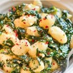 Soft fluffy pillows of gnocchi & tender, sautéed kale, tossed in a creamy, garlic infused sauce. This Creamy Vegan Gnocchi with Garlic & Kale is dinner party worthy but incredibly easy to make, taking less than 15 minutes from start to finish and that includes prep time too!  
