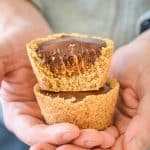 Healthier Chocolate Caramel Cookie Cups nestled in a man's hands