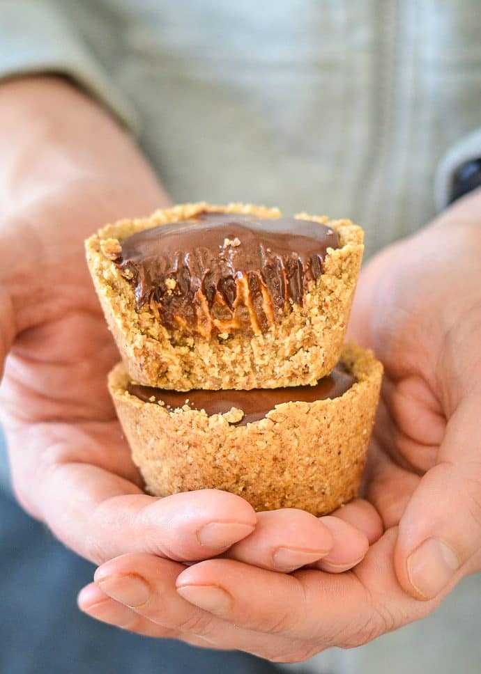 Healthier Chocolate Caramel Cookie Cups nestled in a man's hands