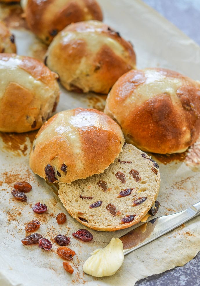 A Hot Cross Bun cut in half with some vegan butter on the side