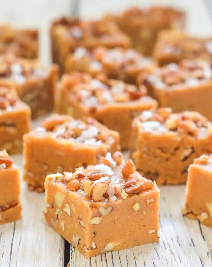 a square of Salted Maple Pecan Vegan Fudge topped with pecans and sea salt flakes