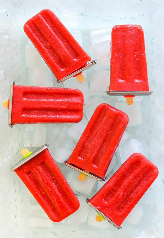 strawberry popsicles laid out on ice cubes