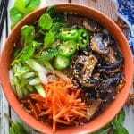 Udon Noodle Soup topped with mushrooms, carrot, green onions, jalapeno and sesame seeds