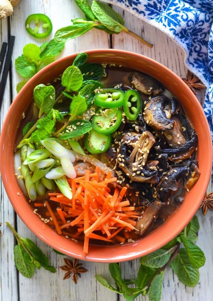 Udon Noodle Soup topped with mushrooms, carrot, green onions, jalapeno and sesame seeds