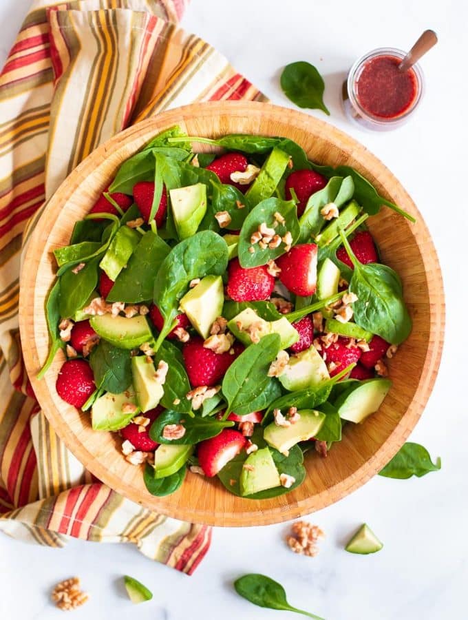 strawberry spinach salad in a wooden bowl
