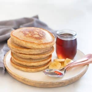Fluffy Vegan Bananan Pancakes with sliced banana and maple syrup