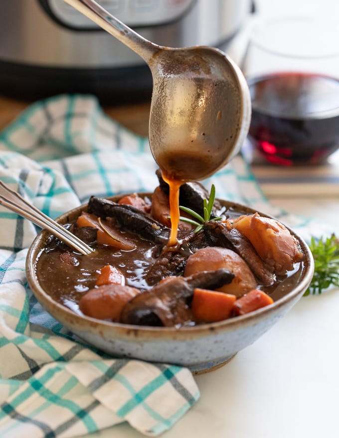 Vegan Portobello Instant Pot Pot Roast being ladled into a bowl 