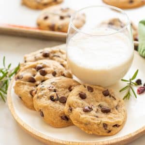 Vegan Chocolate Chip Cookies made festive with the addition of dried cranberries and rosemary! Soft, sweet, chewy, with a lovely subtle woodsy, herbal fragrance. Santa will thank you if you leave him a few of these with his glass of plant milk on Christmas Eve!