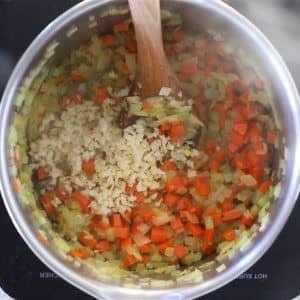 onion, celery, carrot and garlic sautéing in a pan ready to make vegan potato soup