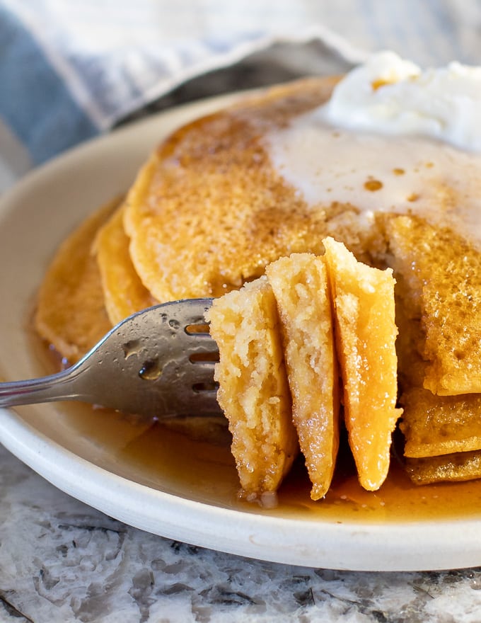 A slice from a stack of Vegan Gluten Free Pancakes on a fork