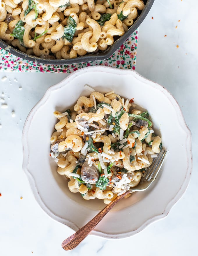 a bowl of Vegan Mushroom Pasta next to a pan full of it 