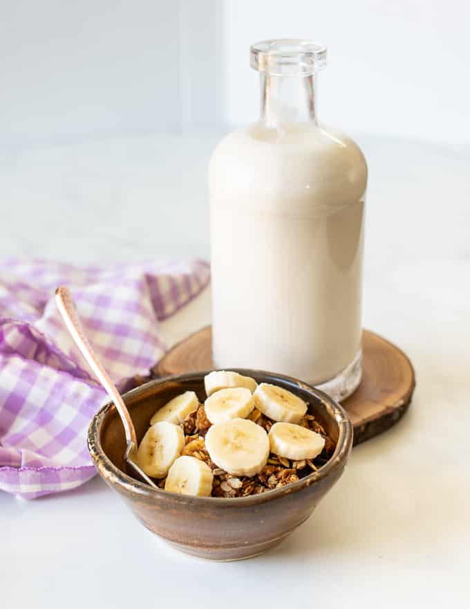 Een kom granola met banaan en een fles melk