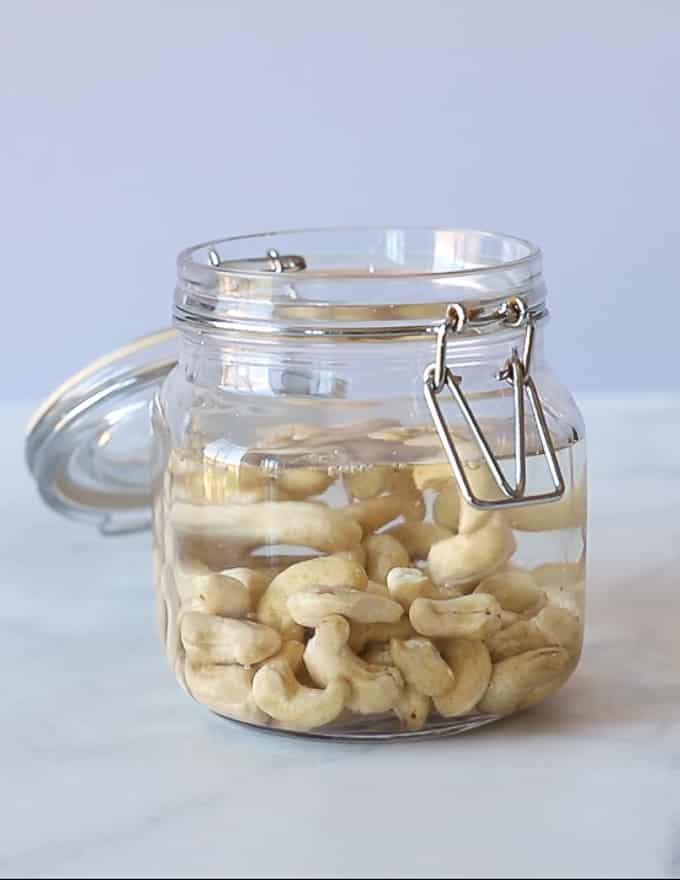 cashew nuts soaking in a jar of water 