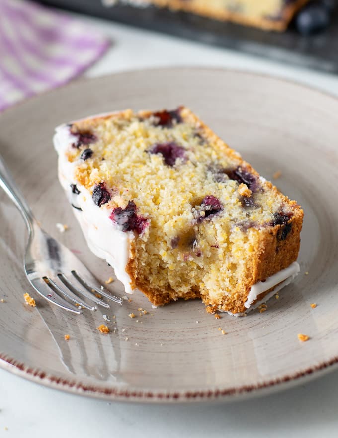 a piece of lemon blueberry loaf with a bite taken out