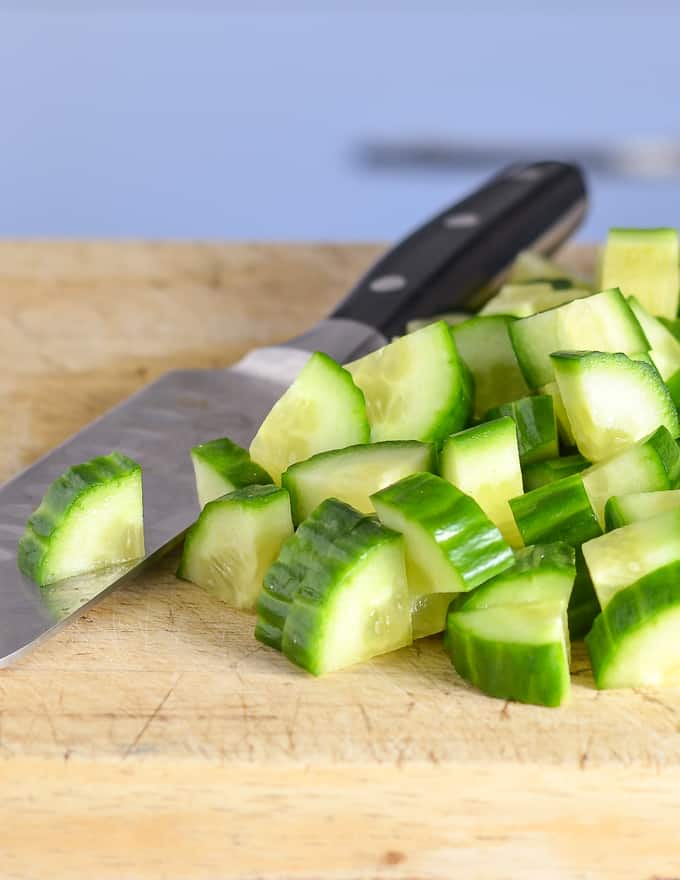 chopped cucumber on a board ready to make Watermelon Mint Salad
