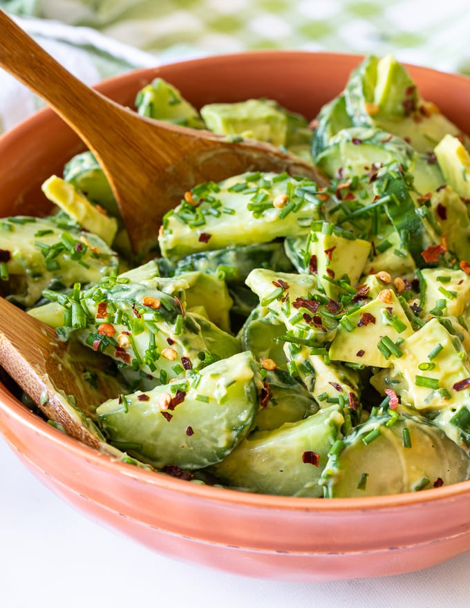 Cucumber Avocado Salad with fresh dill in a bowl with salad servers