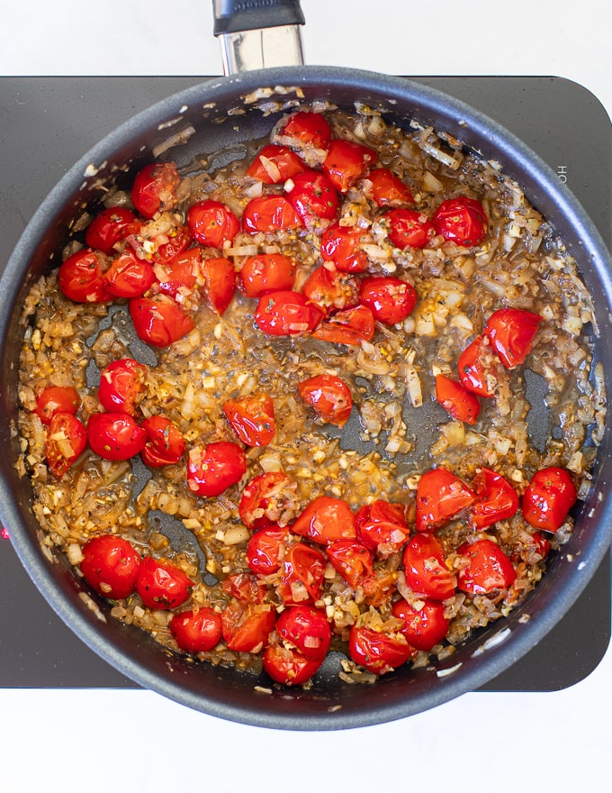 onions, garlic and cherry tomatoes cooking in a pan ready to make Cherry Tomato Sauce