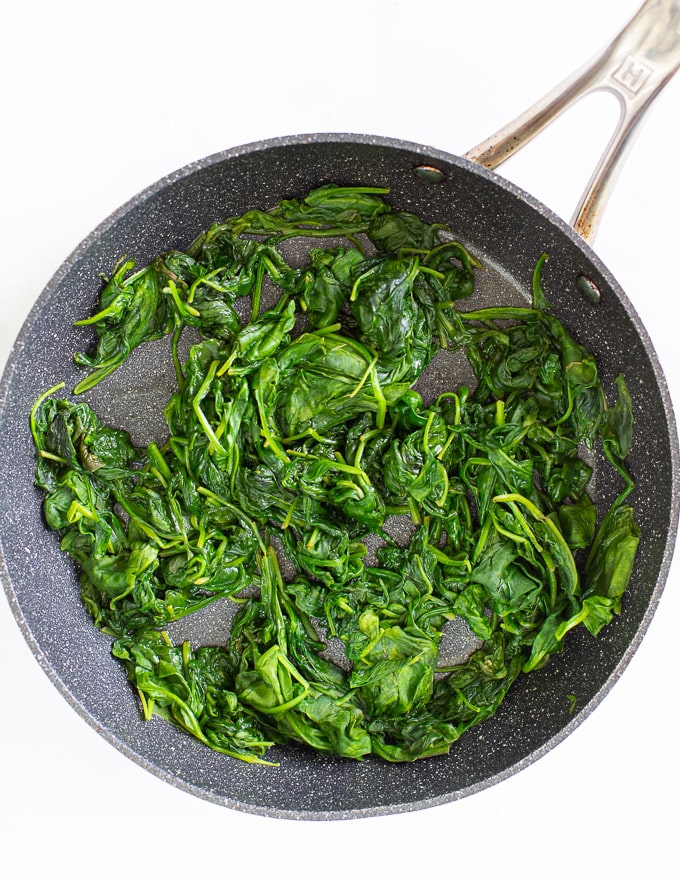 cooked spinach in a pan ready to make vegan spanakopita