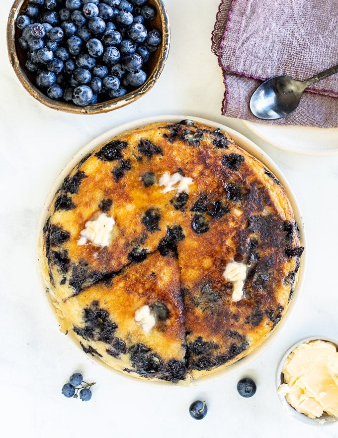 butter melting on a giant vegan blueberry pancake