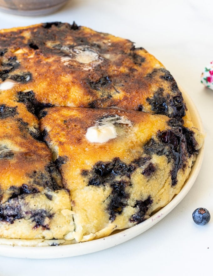 close up of giant vegan blueberry pancake with melted butter