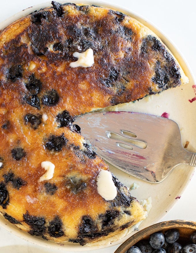 photo of a giant blueberry pancake with a big slice removed