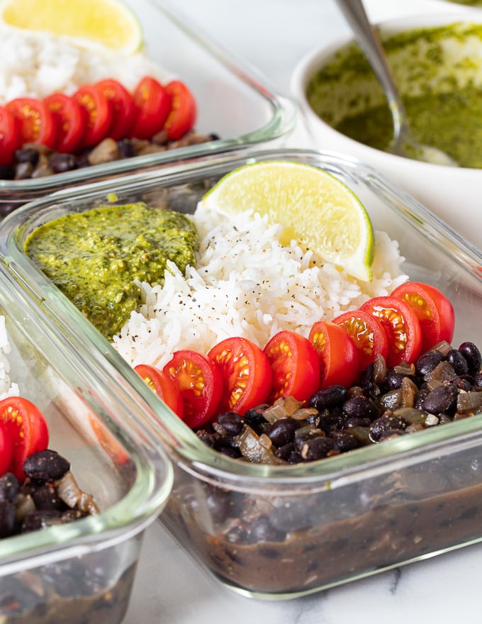 close up shot of a glass vegan meal prep container with black beans and rice 